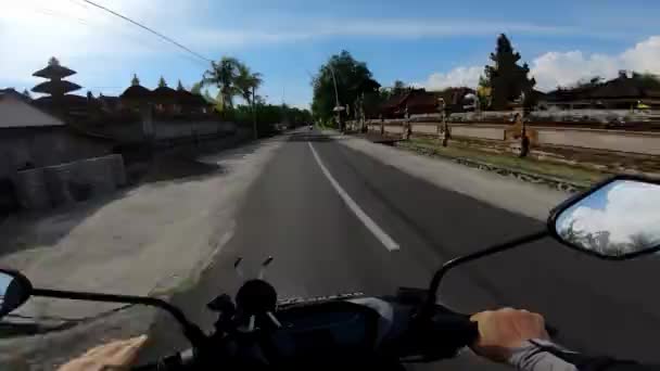 バリの最初の人で舗装道路上のオートバイに乗る — ストック動画