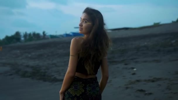 ビデオのA美しいです若いですアジアのブルネット女の子とともに化粧とボディアート上のA体歩行に沿って砂浜と海で背景 — ストック動画
