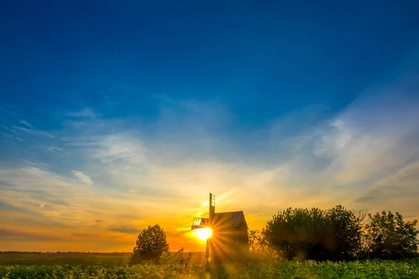 Sunrise en een oude houten windmolen — Stockfoto