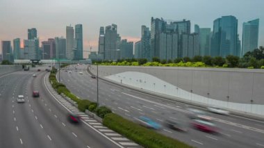 Akşam Singapur. Güçlü araba trafik gökdelenler çerçevede bir karayolu üzerinde. Zaman atlamalı