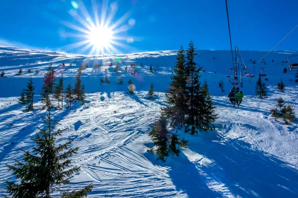 아무런 준비도 되어 있지 않은 스키 슬로프와 의자 리프트 위의 밝은 태양 — 스톡 사진