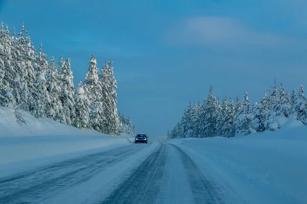 Samotny samochód na przedmieściach autostrady w Snowy Forest — Zdjęcie stockowe