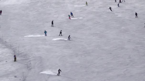 天気の良い日にスキー場 多くのスキーヤーは下り坂スキー スローモーション 空中風景 — ストック動画
