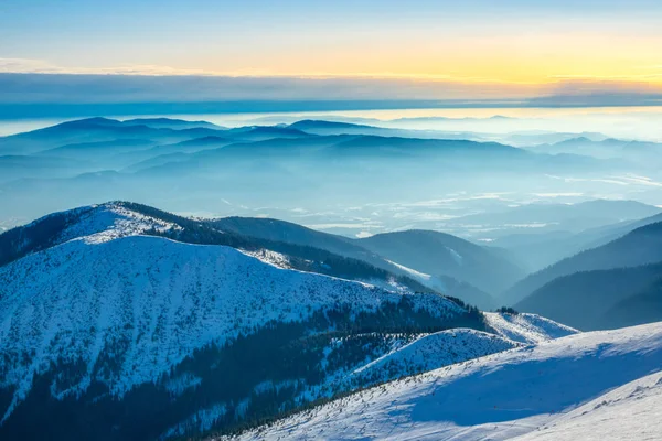 Горные вершины и туман в долинах в зимний солнечный день — стоковое фото