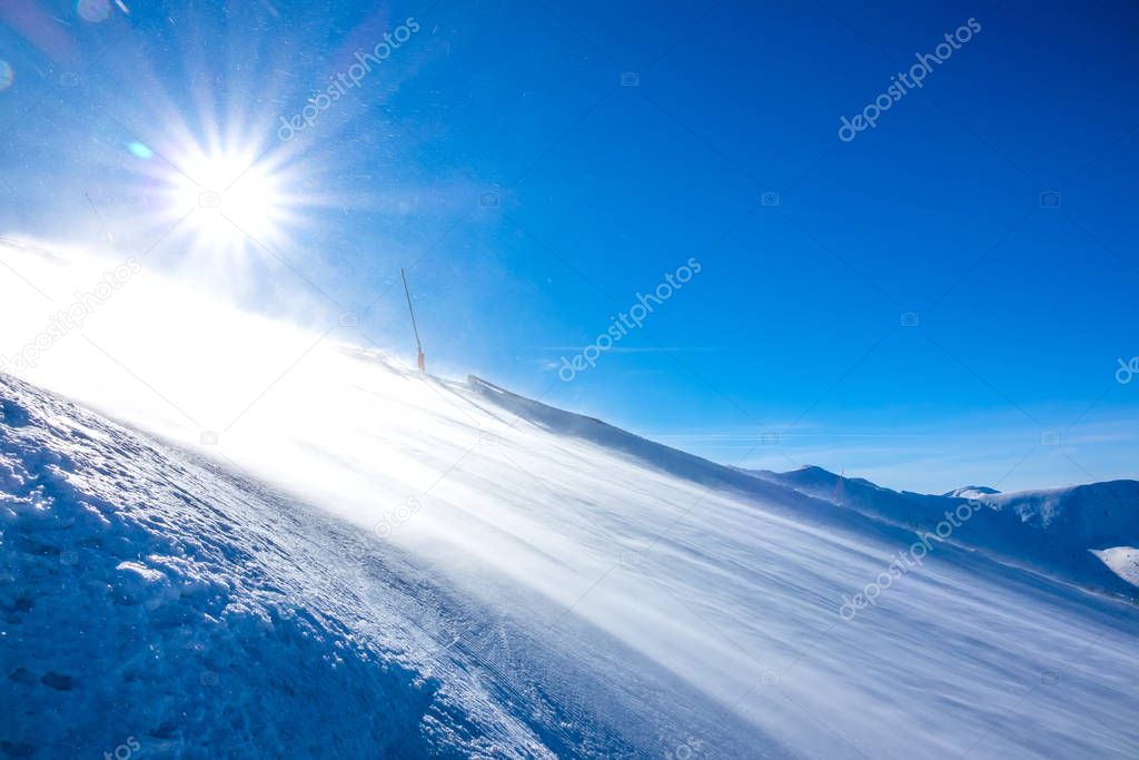 Snowstorm in Sunny Weather on an Empty Ski Slope