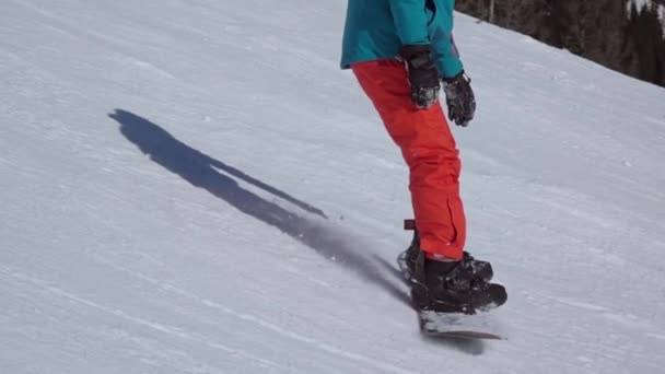 Skidanläggning Snowboard Röd Blå Kostym Går Nerför Skidbacken Långsamma Rörelser — Stockvideo