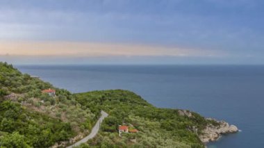 Greece. Summer wooded coast of the Aegean sea. Cottages with red roofs. Overcast sky. Time lapse