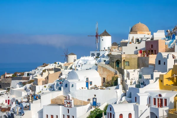 Greece. Santorini (Thira). White houses and windmills on a mountainside in the village of Oia
