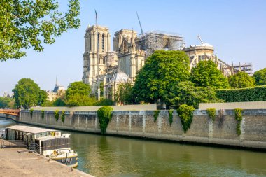Fransa, Paris. Yaz güneşli bir gün. Seine Nehri 'nde yüzen kafe ve arka planda çıkan yangından sonra Notre Dame restorasyonu.