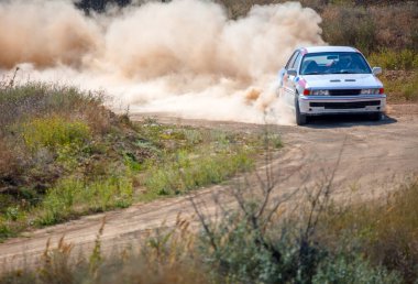 Yaz kuru toprak yolu. Güneşli bir gün. Yarış arabasının keskin virajında çok fazla toz var.