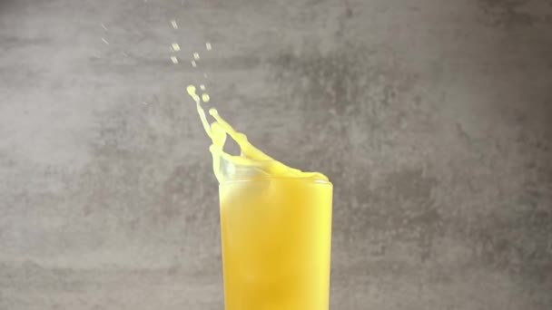 Склянка Апельсинового Соку Кубики Льоду Потрапляють Сік Створюючи Багато Бризок — стокове відео