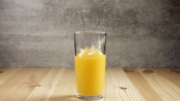 Vaso Con Zumo Naranja Caída Cubo Hielo Creando Montón Salpicaduras — Vídeos de Stock