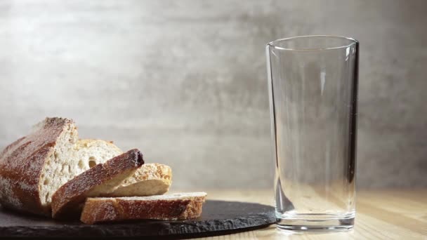 牛奶倒入杯子里 旁边躺着一块面包和两片新鲜面包 慢动作 — 图库视频影像