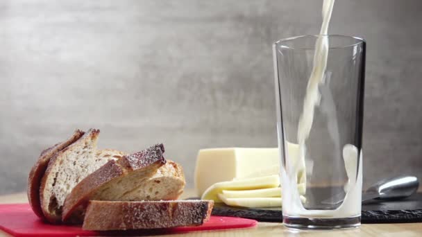 Süt Akıntısı Bir Bardağa Dökülür Yakınlarda Birkaç Dilim Taze Ekmek — Stok video