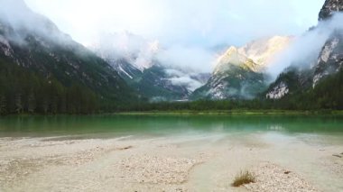 Avusturya. Ormanlık dağların arasında küçük bir göl. Kayalık tepelerde sabah sisi. Hızlı hareket