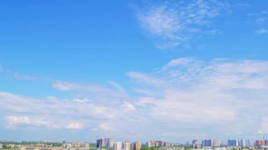 Yaz şehrinin üzerinde mavi gökyüzü. Bulutlar hızlı koşuyor. Panoramik Zaman Hızı