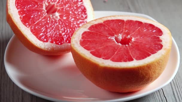 Bílý Talíř Dřevěném Stole Dvě Poloviny Čerstvého Grapefruitu Pár Kapek — Stock video