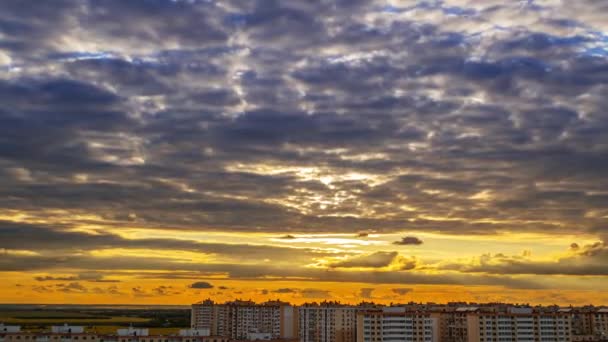 マンションの屋根の上に曇った空 夕日は金の動きの速い雲を着色します 経過時間 — ストック動画