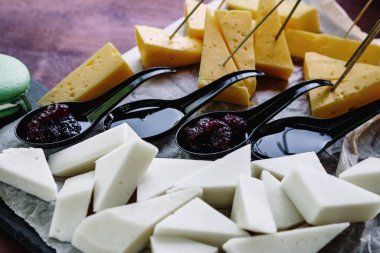 Çeşitli peynir parçaları ve sos.