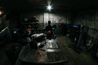 Erkek zanaatkar karanlık atölyede çalışıyor.