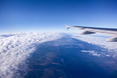 Uçan kanadın ve gökyüzündeki bulutların görüntüsü