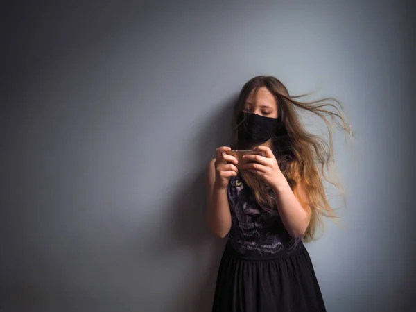 Korumalı Maskeli Bir Kız Karantina Sırasında Evde Tek Başına Telefonla — Stok fotoğraf