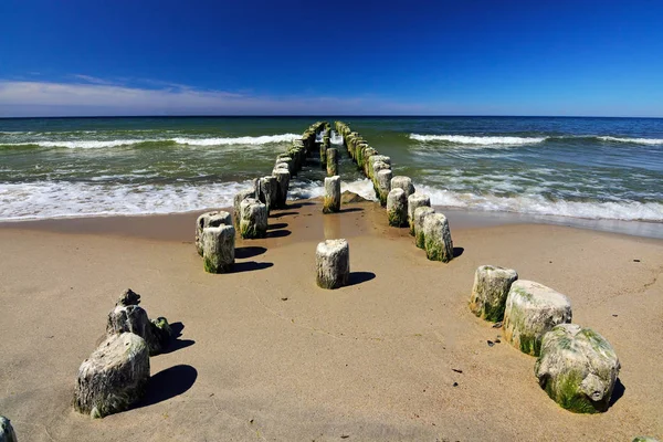 Wooden breakwater retreats into the sea — Stock Photo, Image