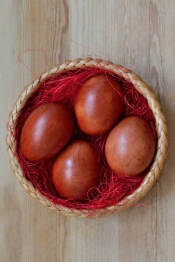 Güzel boyalı tavuk yumurtaları hasır sepette yatıyor.