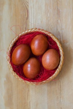 Güzel boyalı tavuk yumurtaları hasır sepette yatıyor.