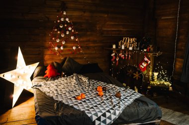 Kanepesi, battaniyesi, şöminesi, yıldızları ve ışıkları olan yeni yıl dekorasyonu