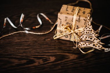 Yapısal ahşap kaplamalı, kahverengi kurdeleli Noel hediyesi kutusu. Yan görünüm, metin için yer.