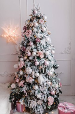 Noel ağacı süslenmiş çelenkler hediye kutularıyla beyaz odada