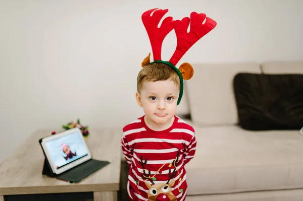Noel Baba süveterleri ve kafasında elbiseler olan mutlu çocuk. — Stok fotoğraf