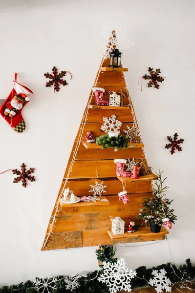 Beautifully decorated Christmas wooden tree on wall with many pr — Stock Photo, Image