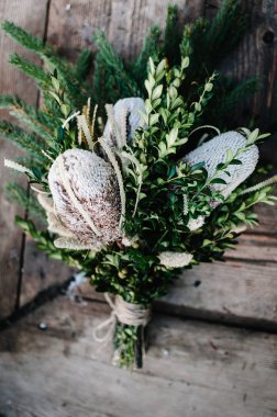 Şık bir buket koni ve ahşap arka planda yeşil çimen.