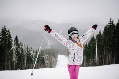Yamaçta duran ve kayak yapmaya hazırlanan kadın Karpatya dağlarında kar yoluna iniyor.