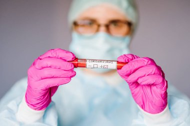 Solunum maskeli hemşire kan testi yapıyor. Sonuç pozitif. Hızlı bir şekilde Coronavirus, Çin 'e yayılıyor. 2019 nCoV için kan örneği içeren tüp. Salgın Corona virüsü salgını.