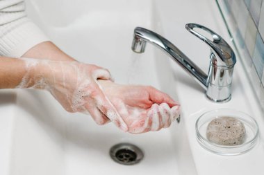 Coronavirus önleme. Ellerini antibakteriyel sabunla yıka ve sıcak akan suyla tırnaklarını ve parmaklarını lavaboda ovala. El yıkama. Salgın Covid-19. Grip hastalığının önlenmesi.