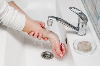 Coronavirus önleme. Ellerini antibakteriyel sabunla yıka ve sıcak akan suyla tırnaklarını ve parmaklarını lavaboda ovala. El yıkama. Salgın Covid-19. Grip hastalığının önlenmesi.