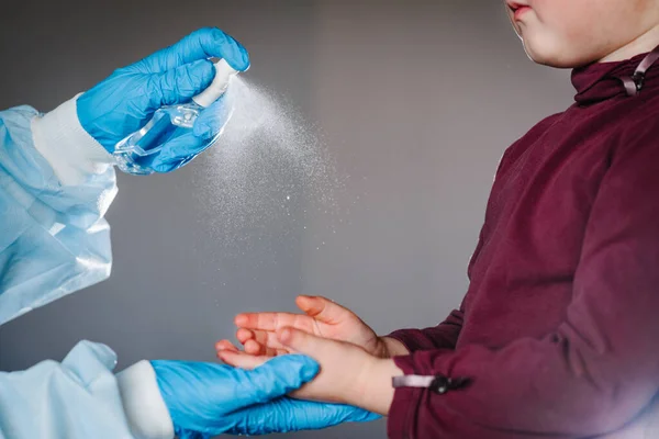 Hemşire ya da doktor el dezenfektanı jeli kullanır. Ellerini ovuşturur, çocuk ellerini ovuşturur, koronavirüs salgınını önler. Çocuk antibakteriyel sabun kullanıyor..