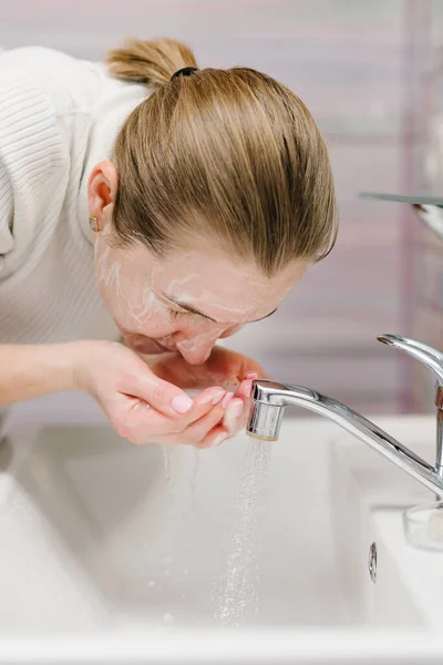 Coronavirus prevention. Wash face with antibacterial soap and running water in sink. Washing face. Epidemic Covid-19. Coronavirus prevention body hygiene. Flu disease.