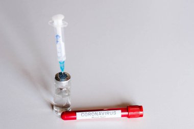 Coronavirus aşısı. Test tüpünde biyolojik kan örneği ve bir masaya şırınga ve hastalık aşısı. 2019-NCov. Hasta sağlığıyla ilgili tıbbi teşhis. Laboratuvar testi - yeni sonuç.