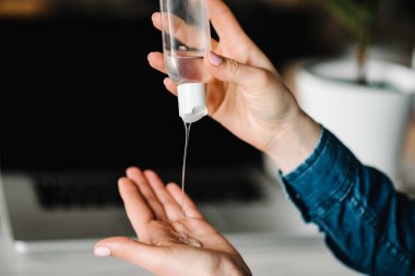 Coronavirus. Dezenfekte jeli. Evde çalışan iş kadını, karantina. Mikropları yok etmek için bakteriyel jel temizliyorum. Evde kal. Kız öğreniyor, dizüstü bilgisayar kullanarak. Serbest çalışıyorum. Covid-19 virüsünü engelle.