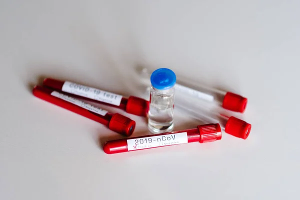 Coronavirus. Biological blood samples in test tubes and vaccine for the disease on a white background. 2019-nCov. Laboratory test - positive result. Blood is infected. New cases of infection. Updates.