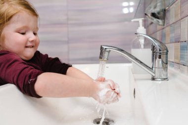 Coronavirus 'un önlenmesi, grip hastalığı. Çocuk, çocuk antibakteriyel sabunla, sıcak suyla ovalayarak ve parmaklarını lavaboya sürterek ellerini yıkar. El yıkama ve hijyen. Covid-19. Koronavirüsü yaymayı bırakmak için..