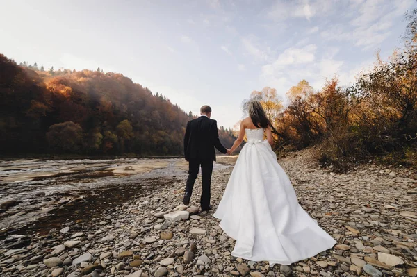 Nevěsta Bílých Šatech Ženich Jít Řece Skály Držet Ruce — Stock fotografie