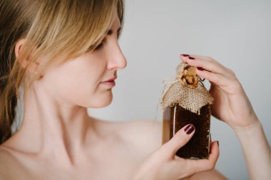 Kavanozda ya da şişede tutulan kadın nemlendirici krem, şampuan, saç kremi, duş jeli ya da vücut fırçası, gri arka planda losyon izolasyonu. Kozmetik güzellik. Cilt bakımı.