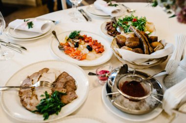 Şenlik masasında yemek servisi yapıyor. Yemek, salata, et, balık menüsü. Düğün ziyafetinde şölen masası. Dekorasyon. Ayrıntılar.