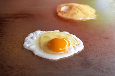 Kahvaltıda sıcak tavada yumurta pişirmek.