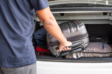 Gezgin arabanın bagajından bir valiz aldı.